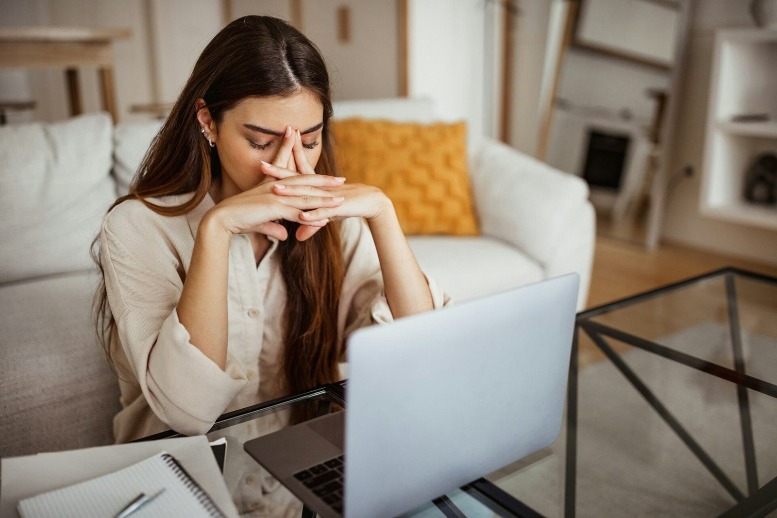 Unhappy tired millennial mixed race female with laptop suffering from overwork, pressure, migraine